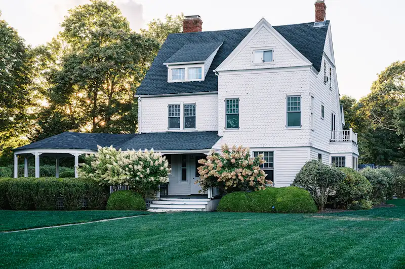 Traditional two-story shingle house with hydrangeas
